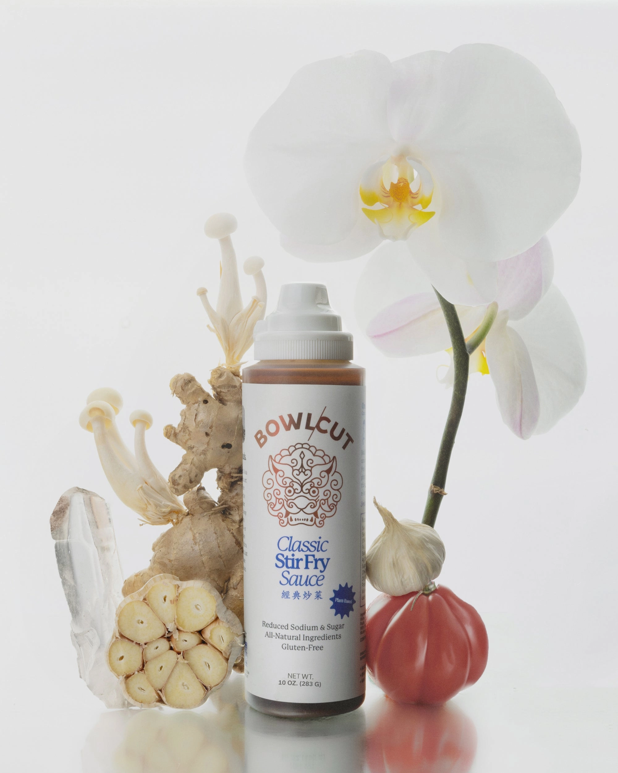 Classic Stir Fry Sauce bottle beside an orchid, garlic and mushrooms