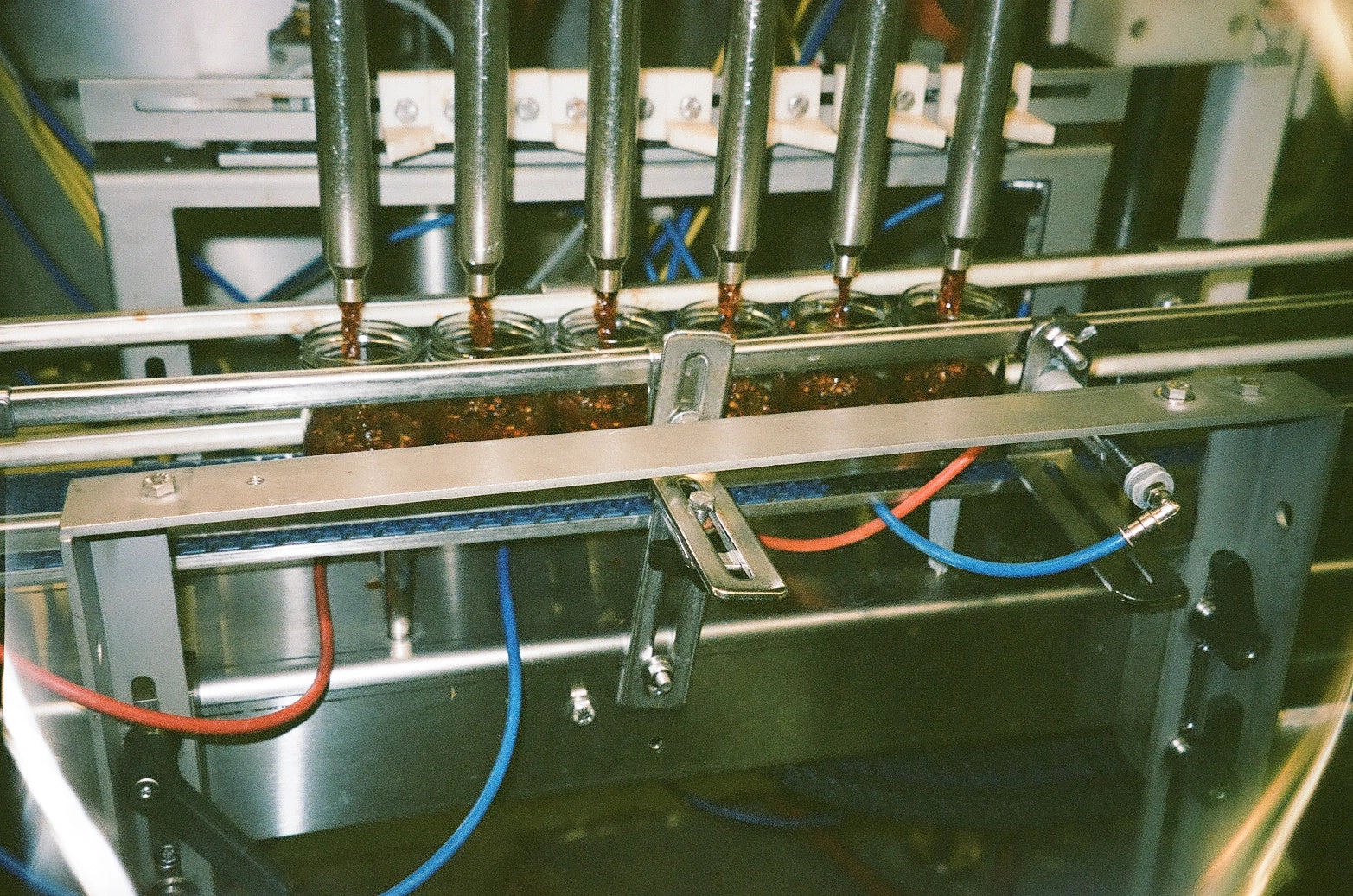 Jar-filling machine with nozzles on a production line