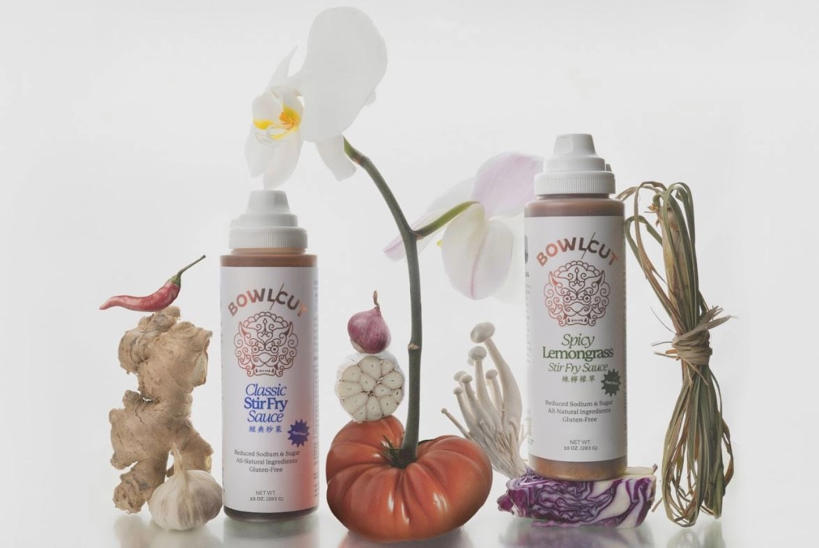 Two Bowlcut stir fry sauce bottles with an orchid, ginger and a tomato